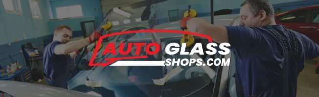 Technicians replacing car windshield in auto glass shop